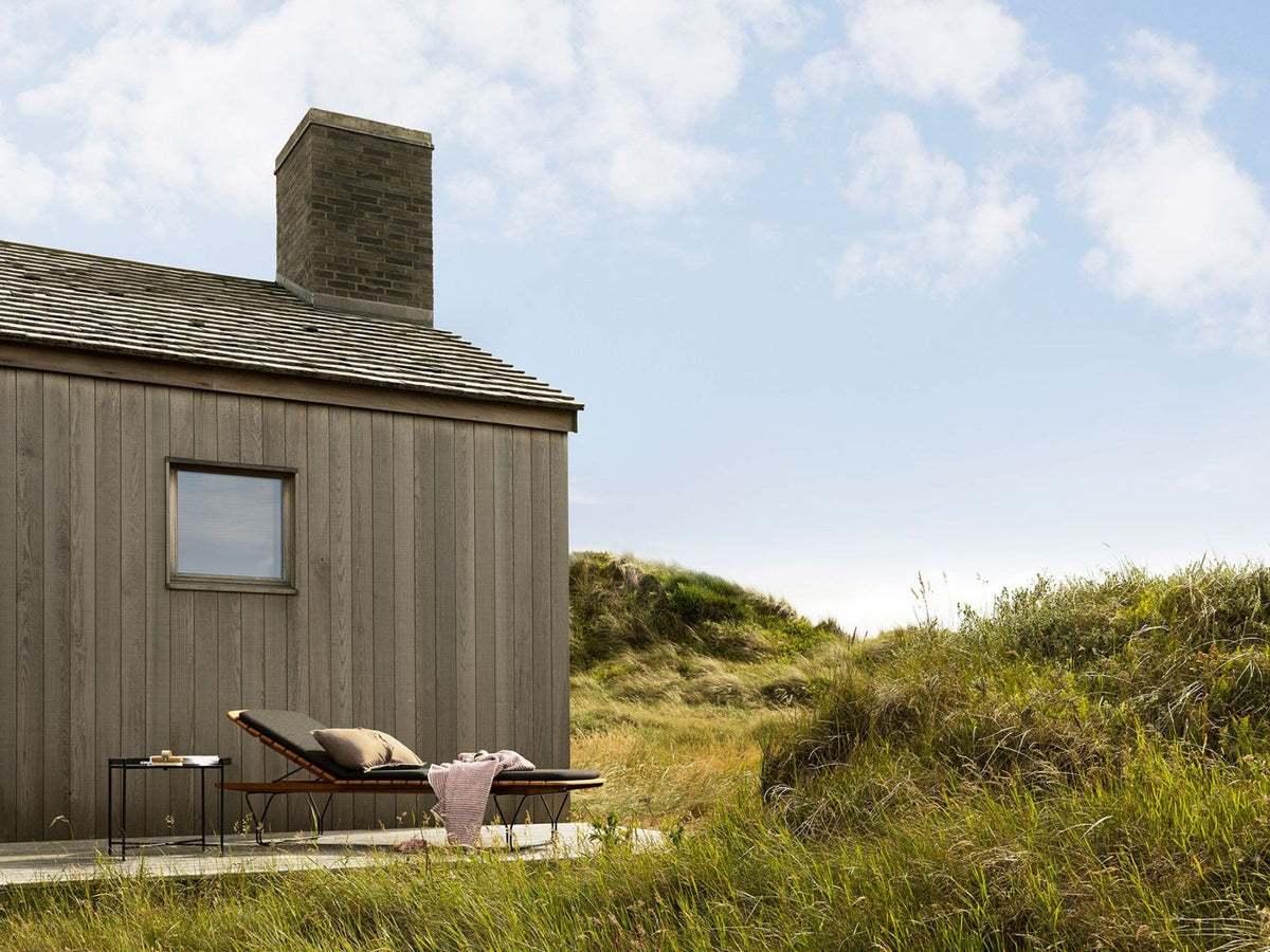 Molo Charcoal House with lounge chair in grassy landscape