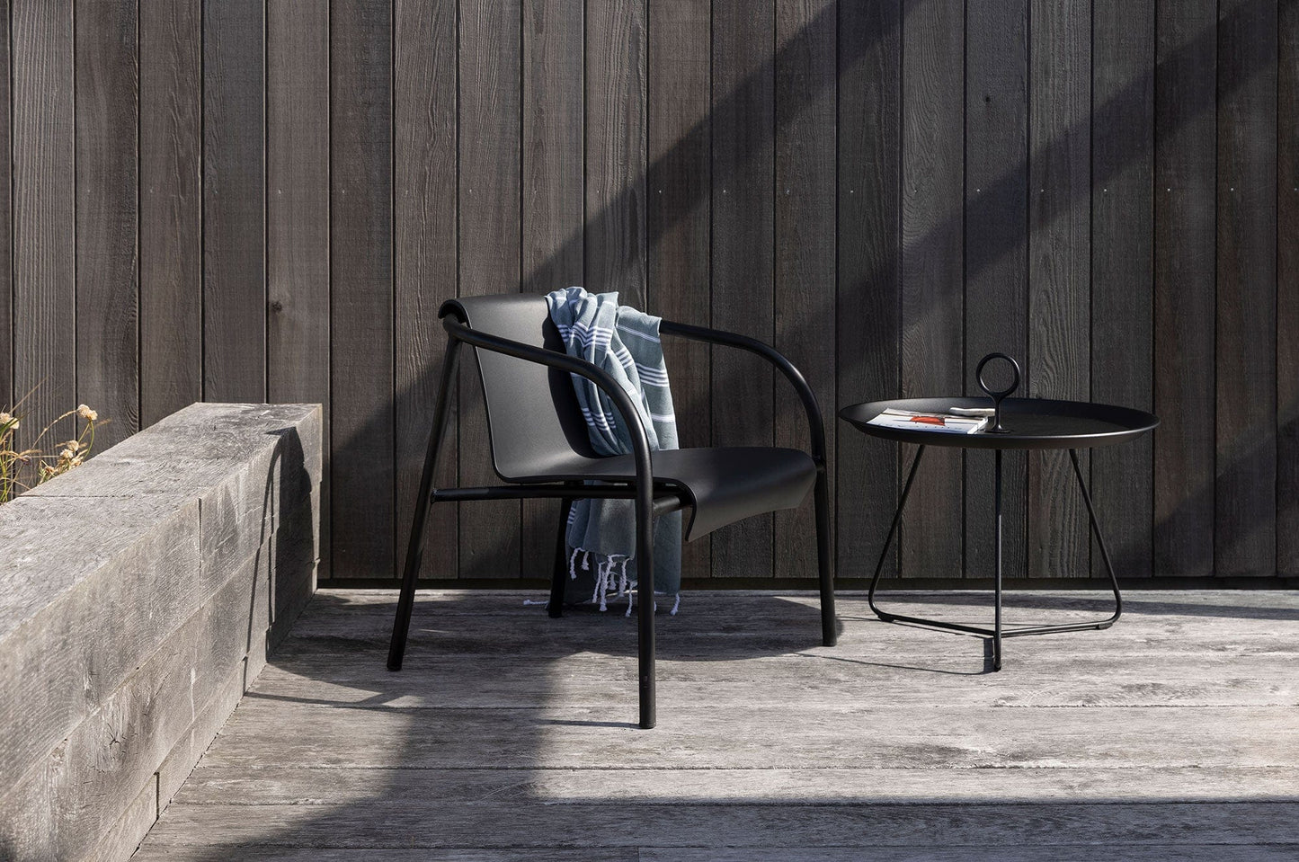 Black EYELET lounge chair and Houe table on deck