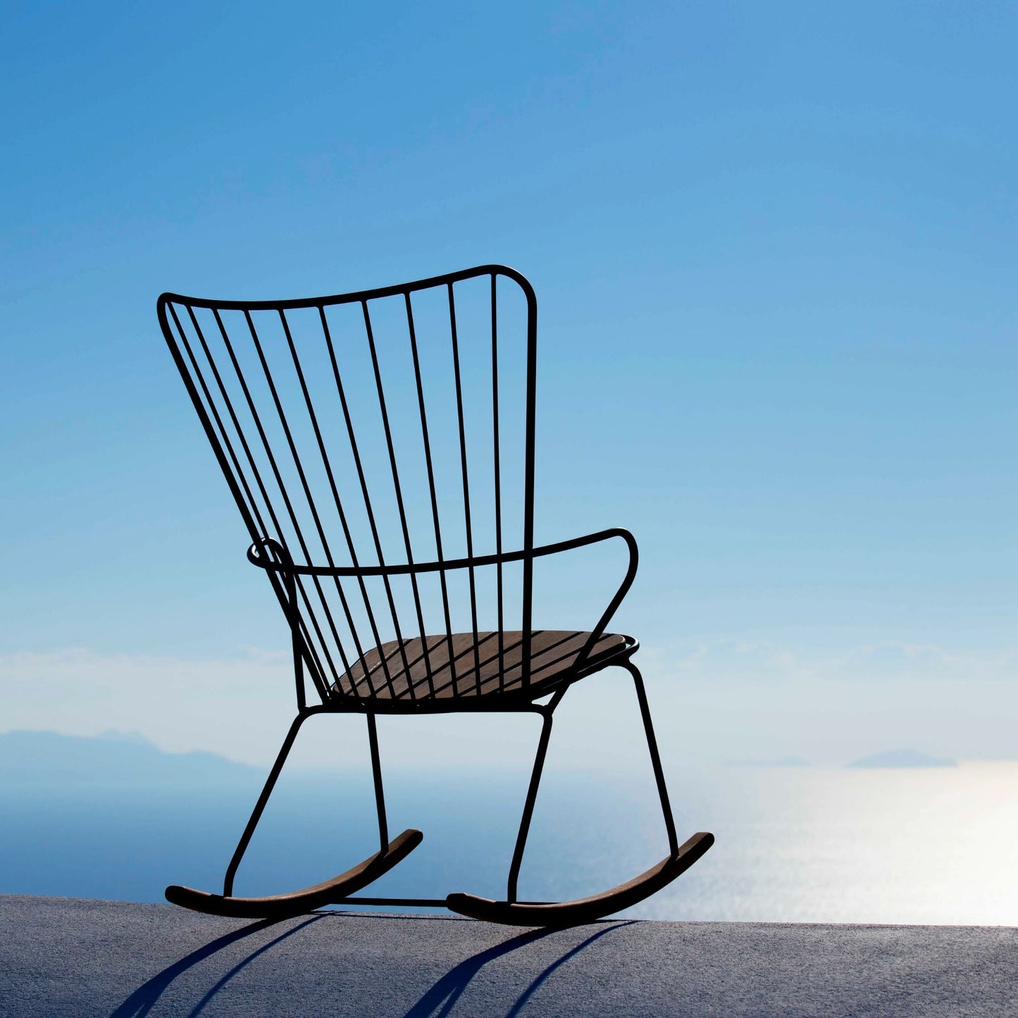 PAON rocking chair with cushion against blue sky