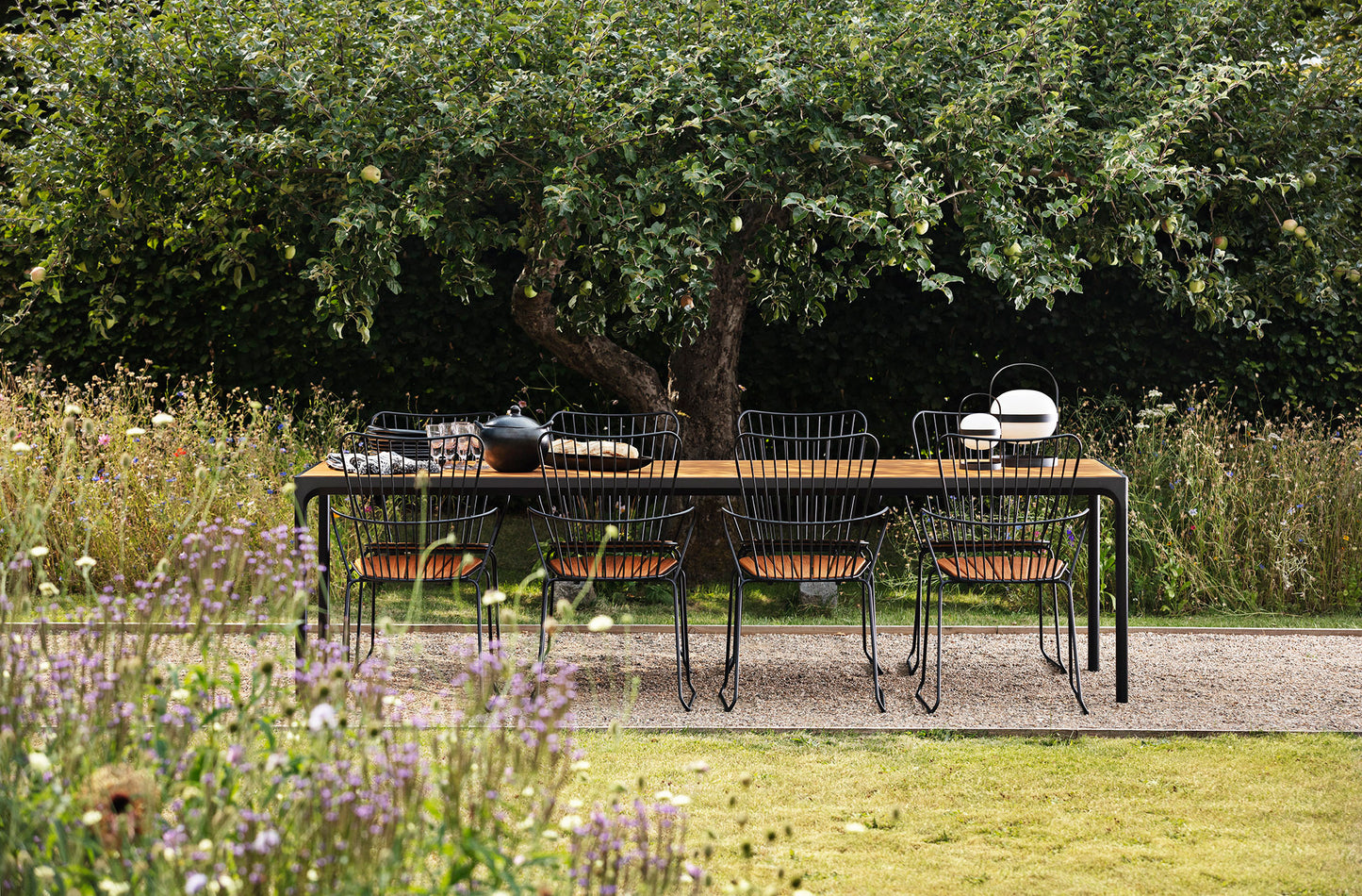PAON black dining table with four bamboo chairs in outdoor setting