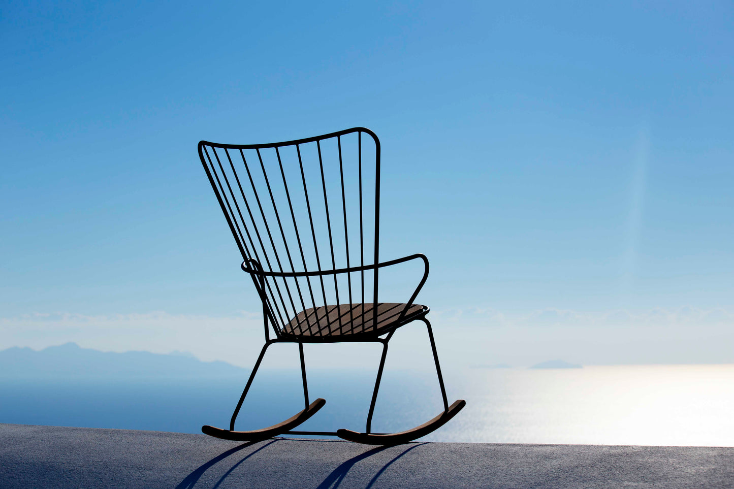 Black HOUE PAON rocking chair against blue sky