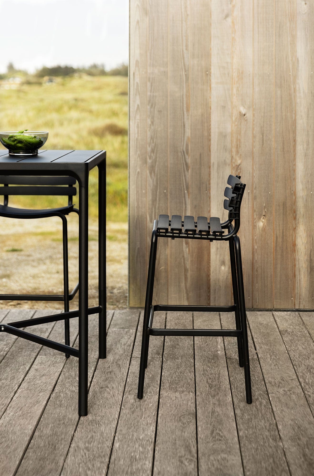 Black ReCLIPS bar stool and table on outdoor deck
