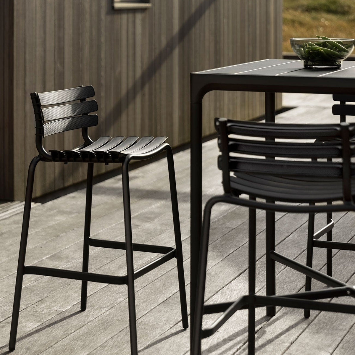 Black ReCLIPS bar stools on a deck.