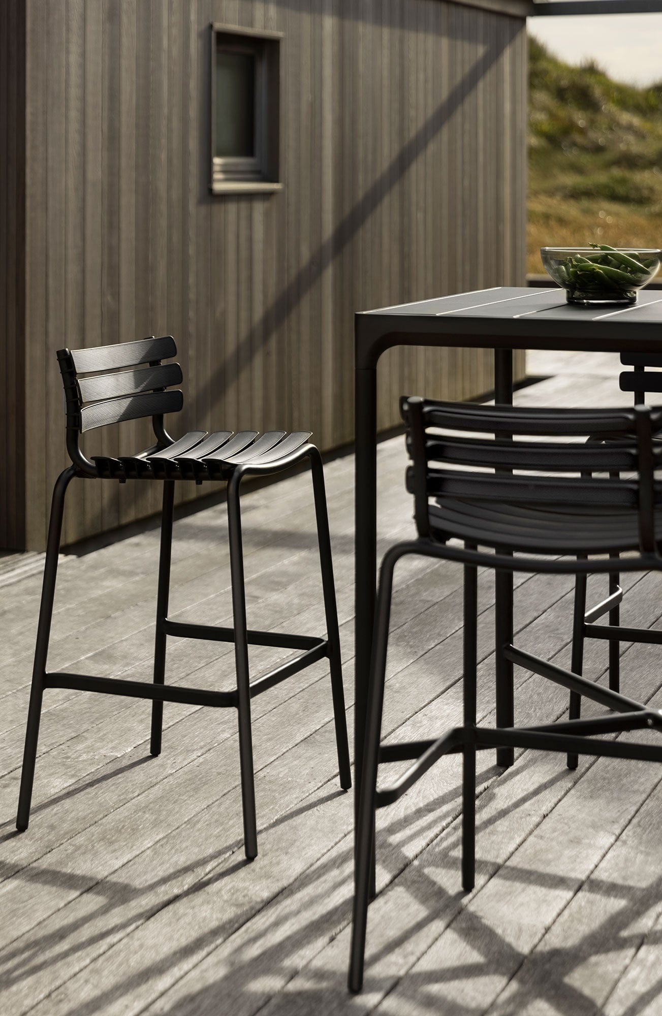 Black ReCLIPS bar stools on a deck.