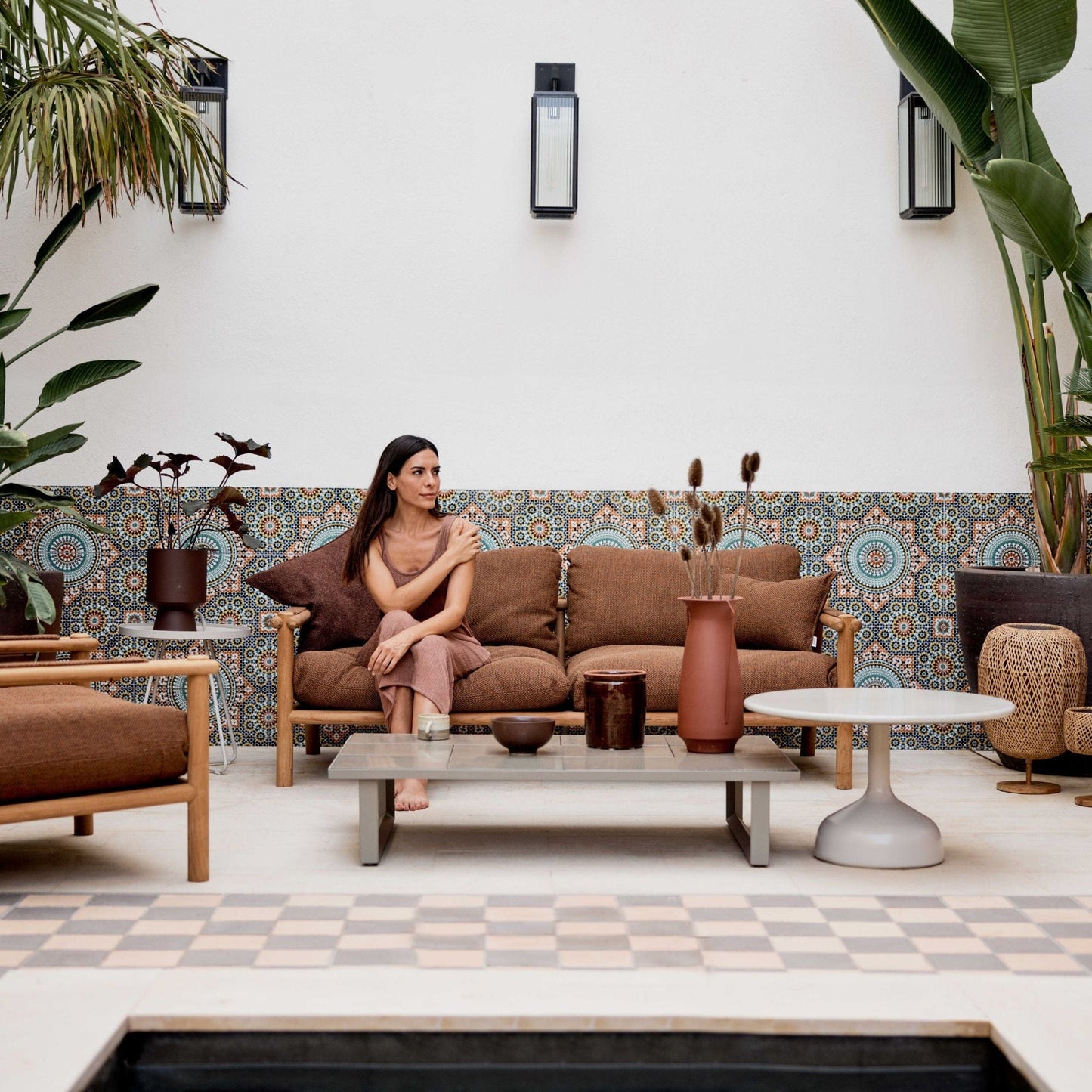 Woman on STICKS 2-seater sofa in outdoor patio
