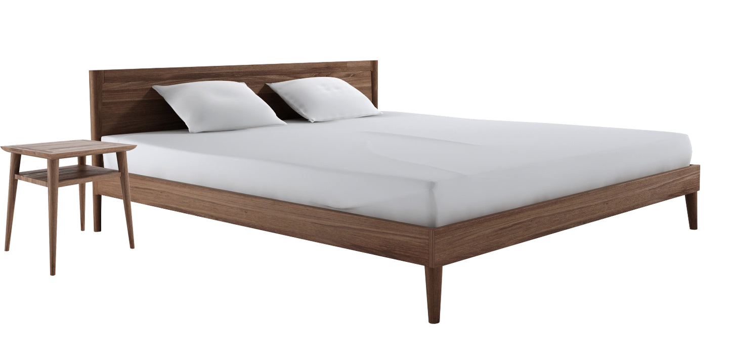 Vintage teak bed with deep-etched headboard and bedside table.