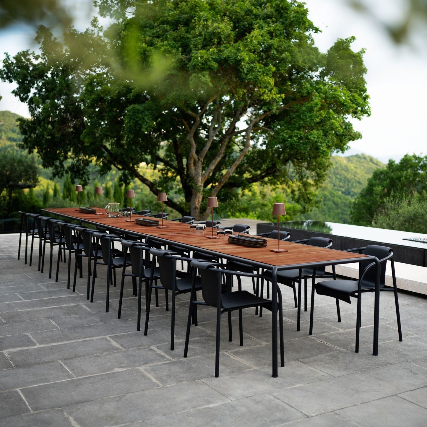Avantitablehoue outdoor dining table with black chairs.