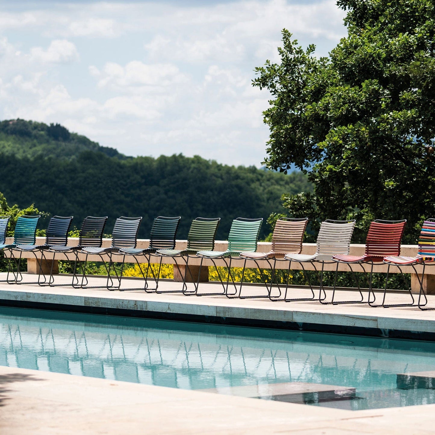Click Colours no-arm chairs lined up by a pool