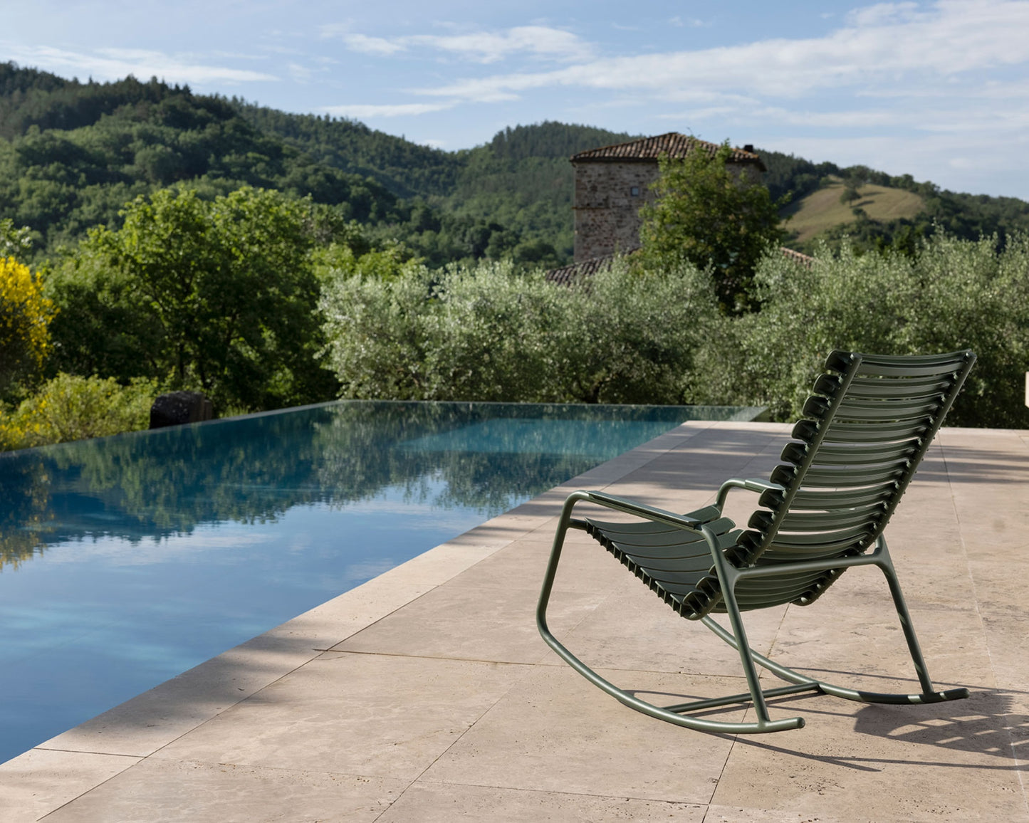 Olive green rocking chair by pool