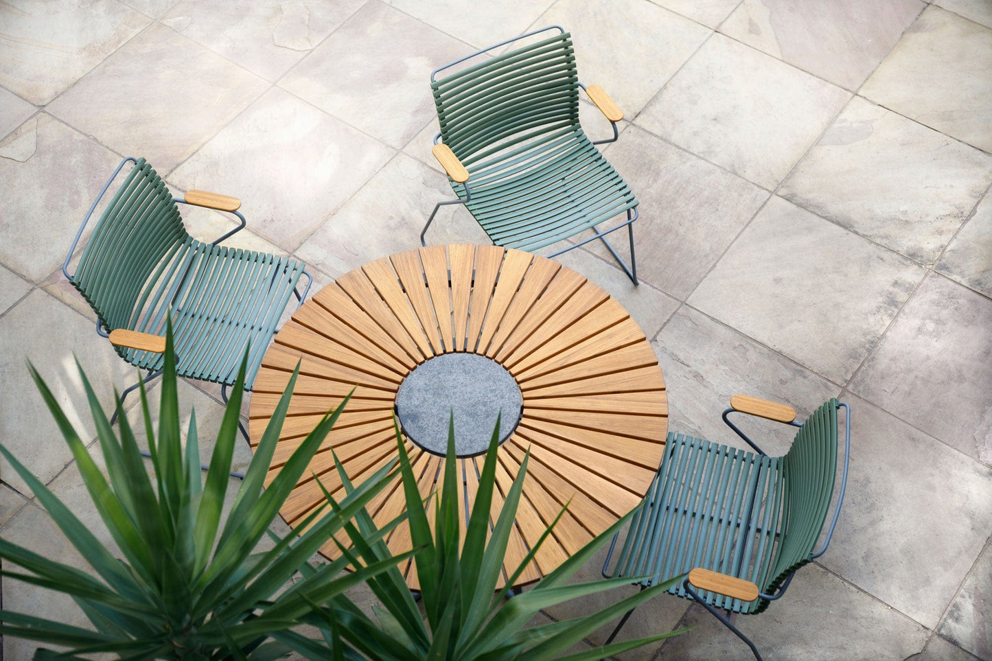 Table and three chairs on a patio.