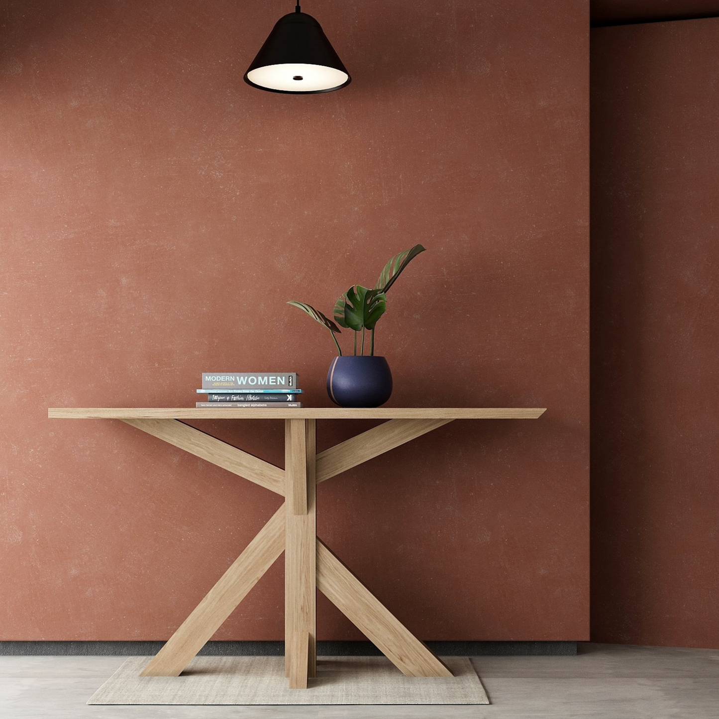 Wooden table with plant and books under a hanging lamp.
