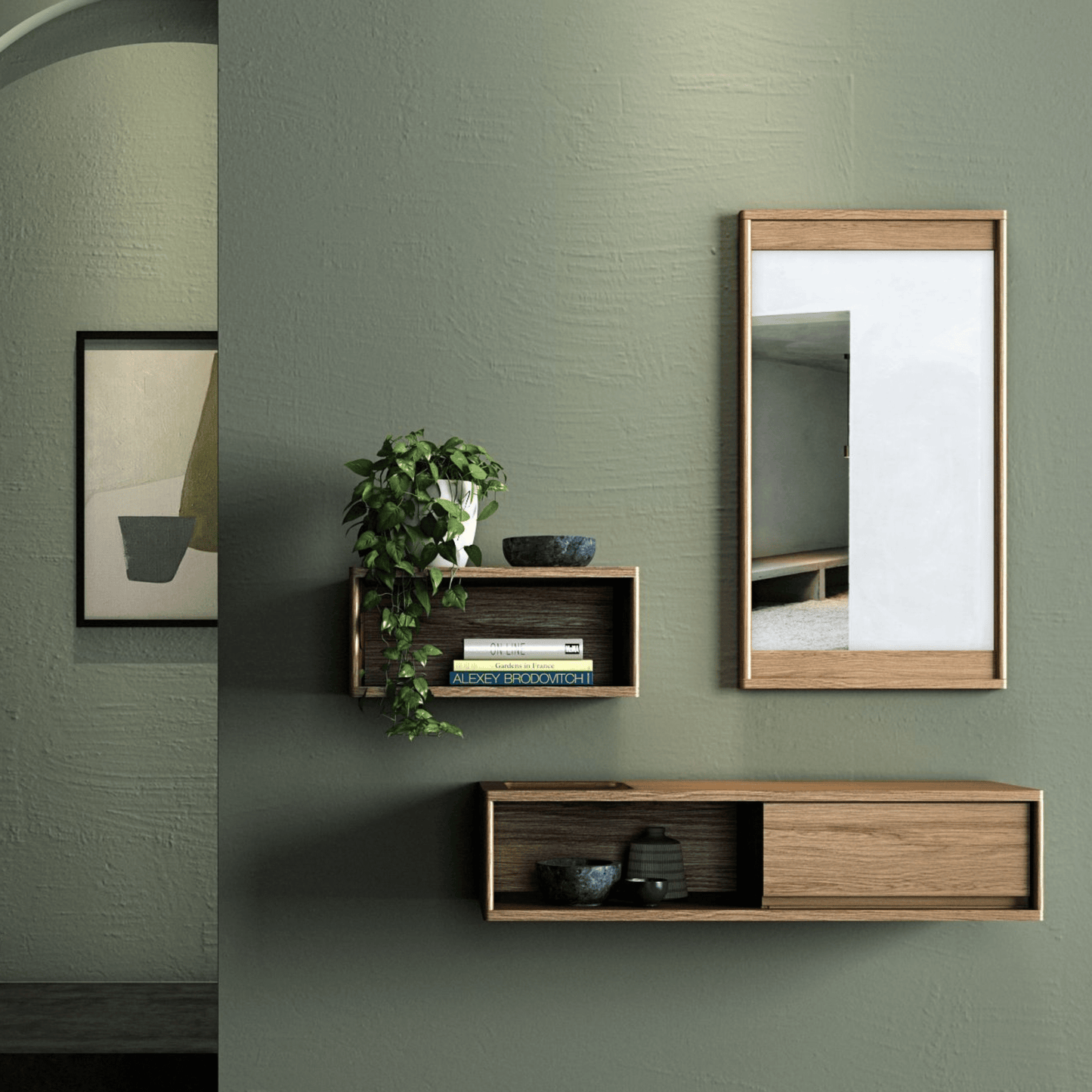 Wall-mounted shelves, mirror, and artwork on a green wall.
