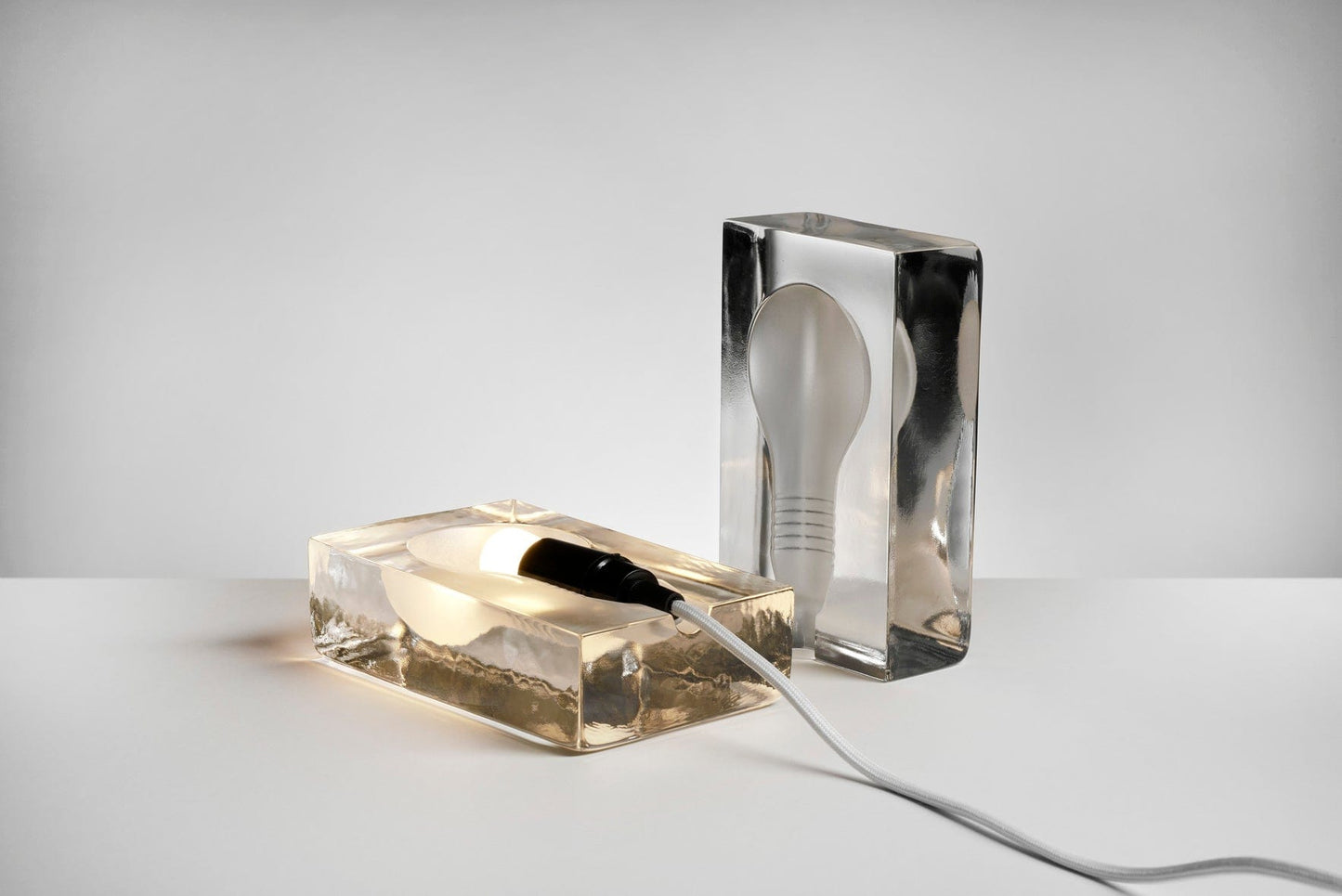Two light bulbs encased in clear blocks.