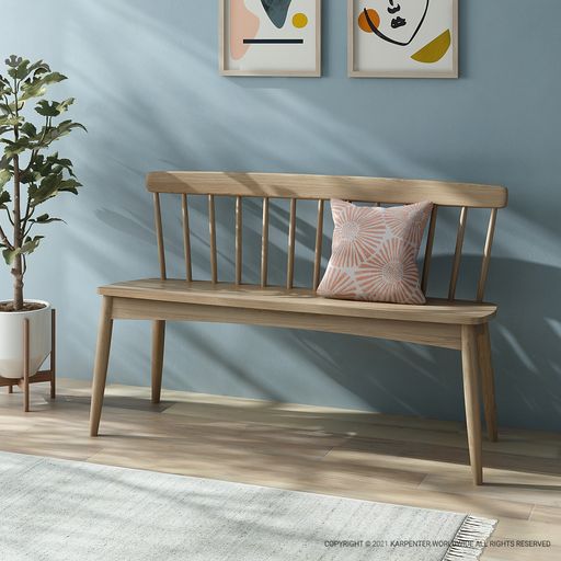 Ch18-CXA wooden bench with back and pink pillow, in front of art.