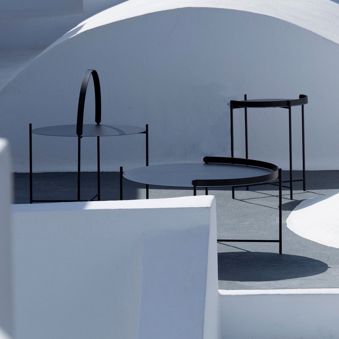 Black EDGE side tables on white exterior.