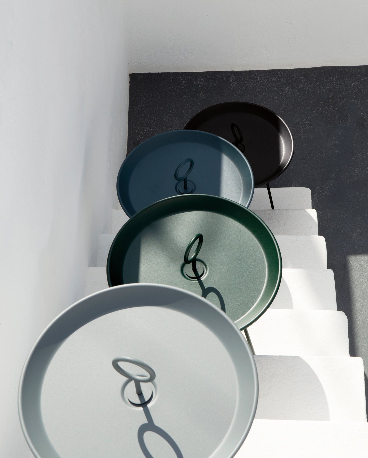 Stacked colored trays on white stairs