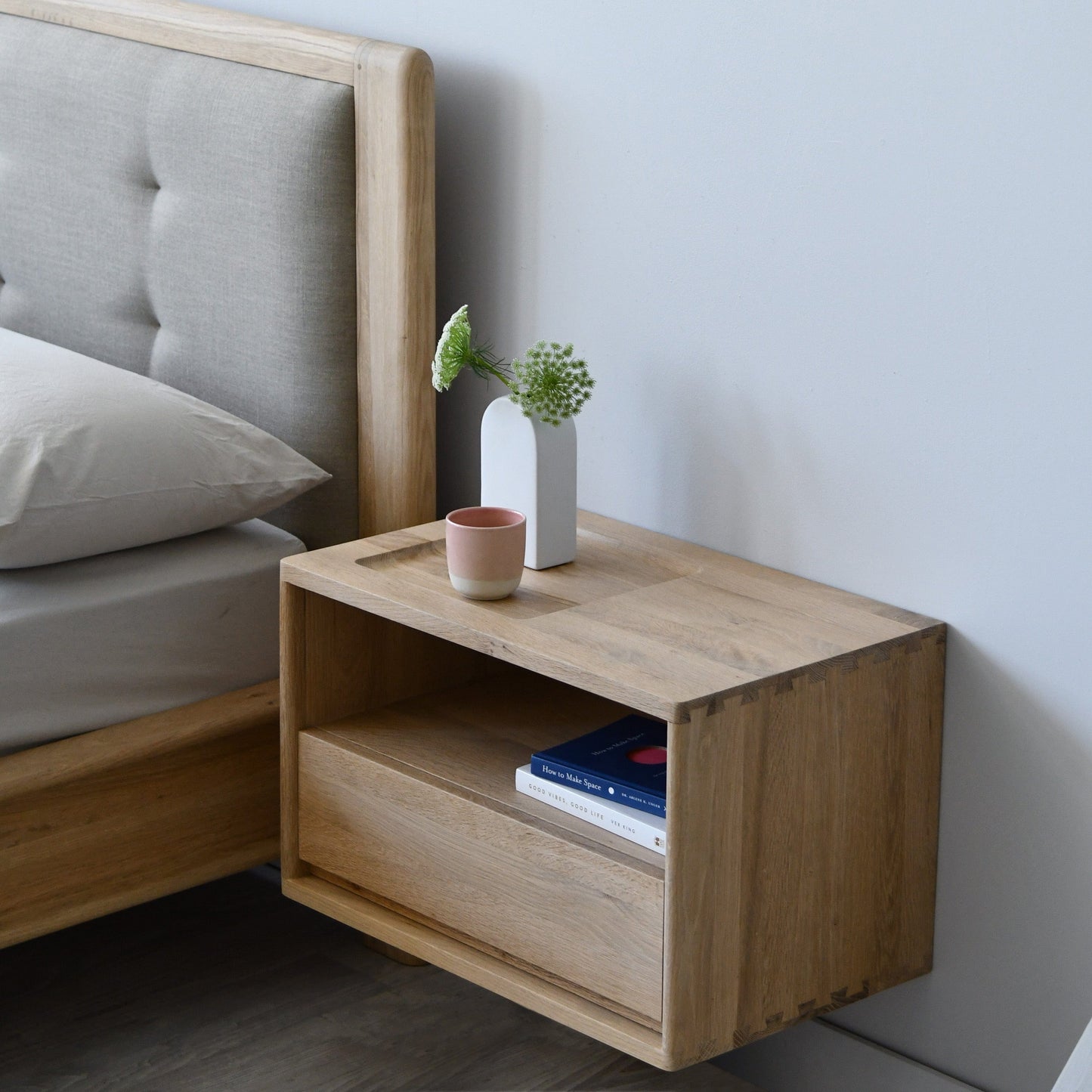 KCC39LO_4 Oak floating nightstand with drawer, books, and decor.