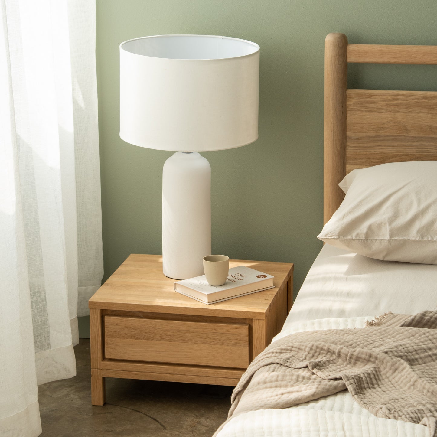 White lamp on wooden nightstand in bedroom
