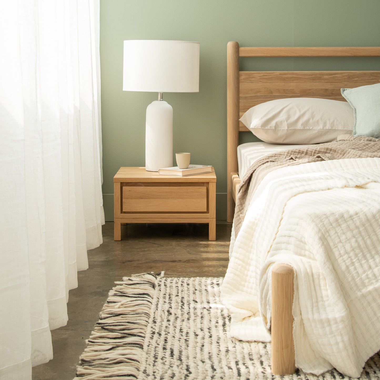 Bedroom nightstand with lamp and bed
