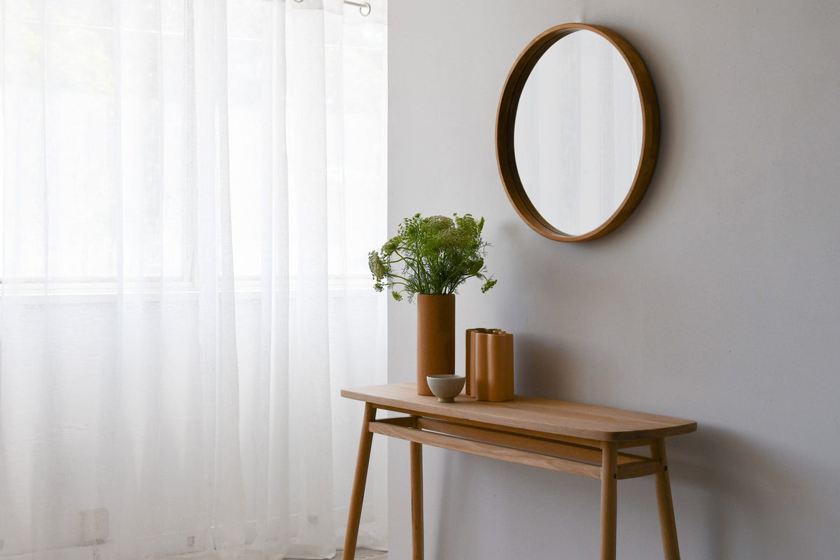 Wooden console table with mirror and decor.