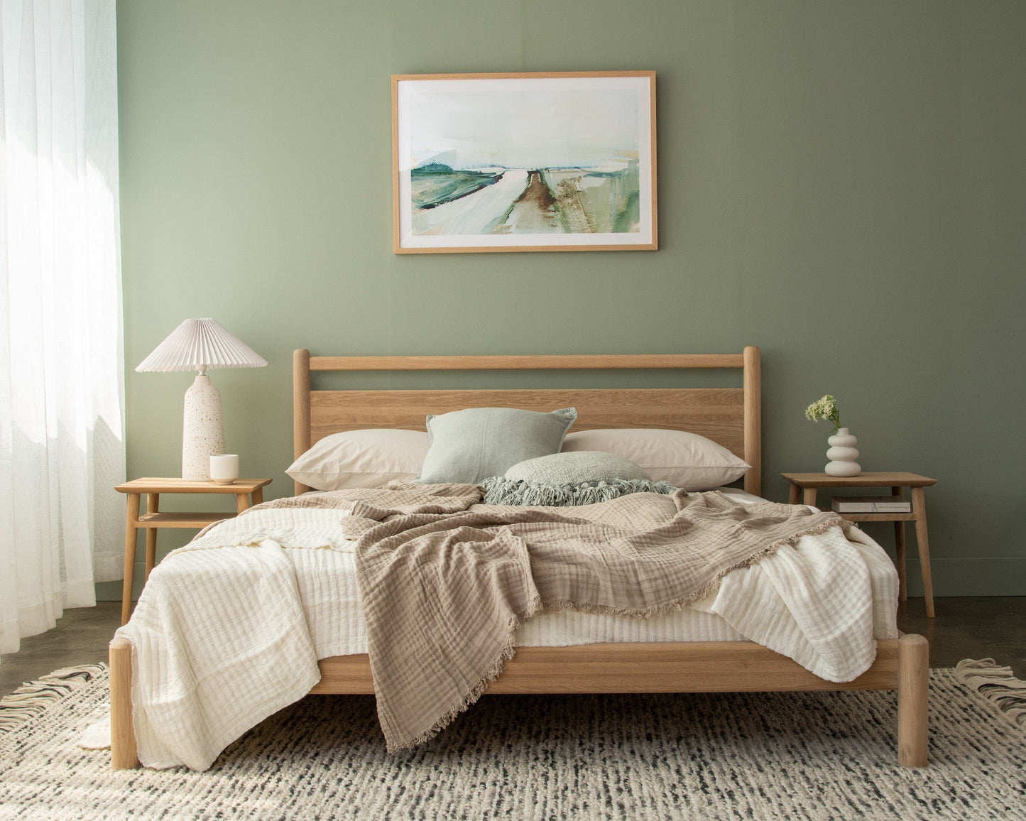 Wooden bed frame KTA010OKV0037O_12 with bedding and artwork.
