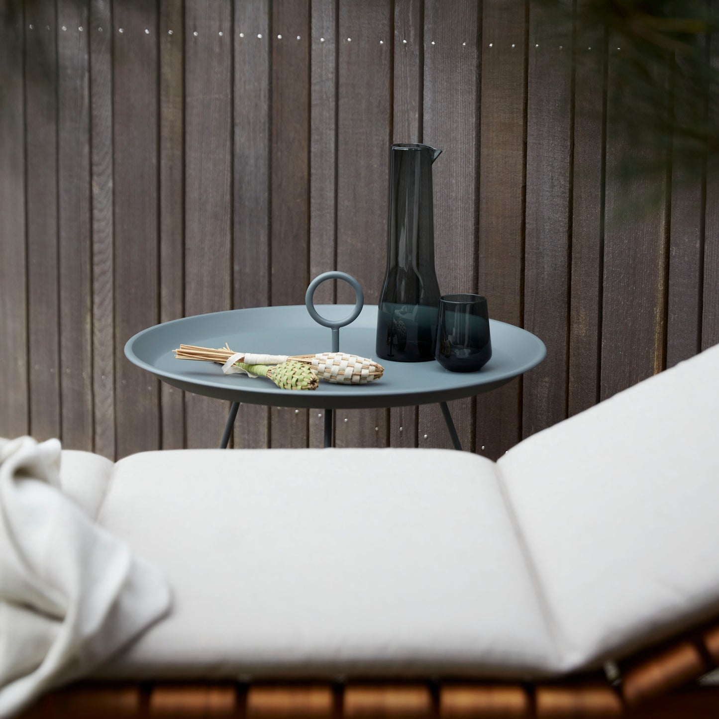 MOLO ash EYELET table with glass and decorative items.