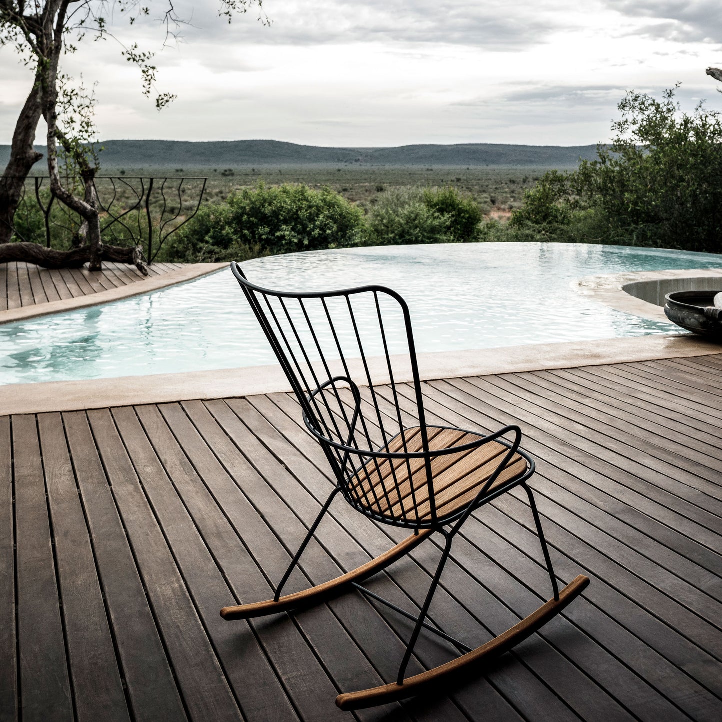 Outdoor rocking chair by pool with scenic view