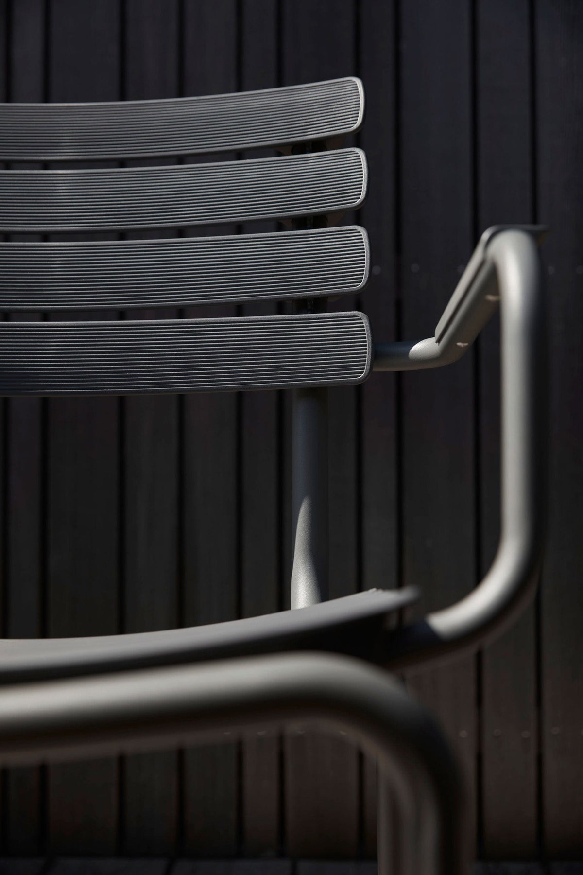 Closeup of ReCLIPS chair against dark wood.