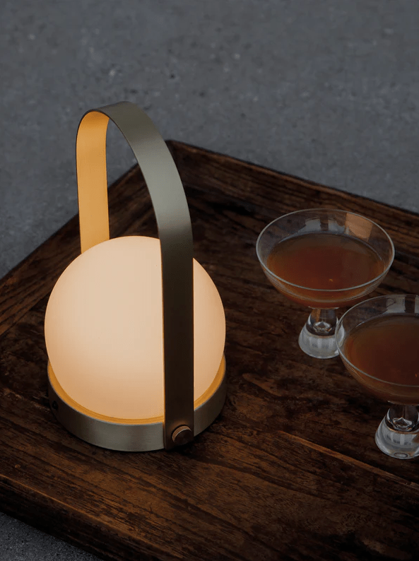 Glowing orb lamp with cocktails on tray.
