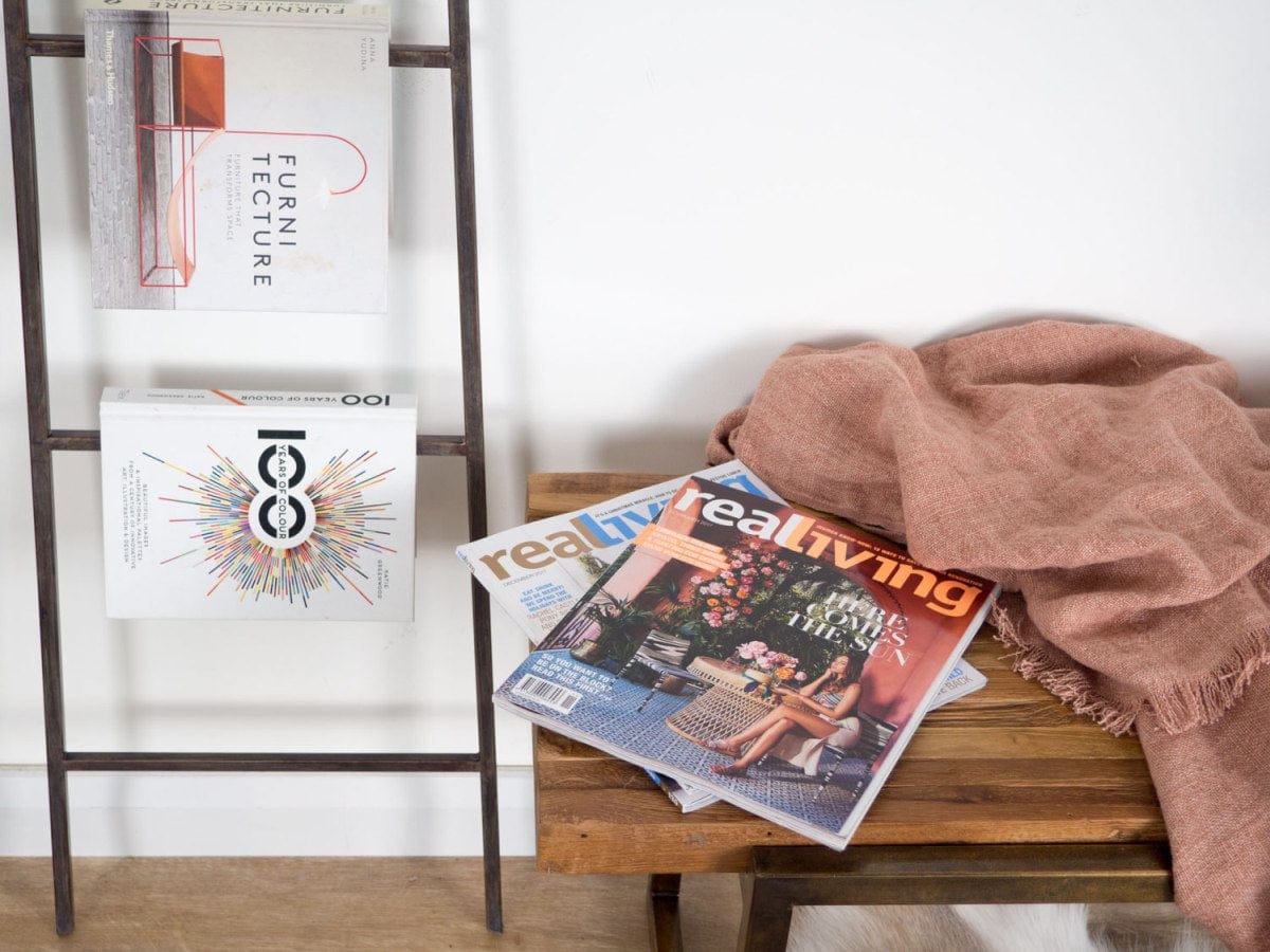 Magazines on ladder shelf and bench, including Real Living.