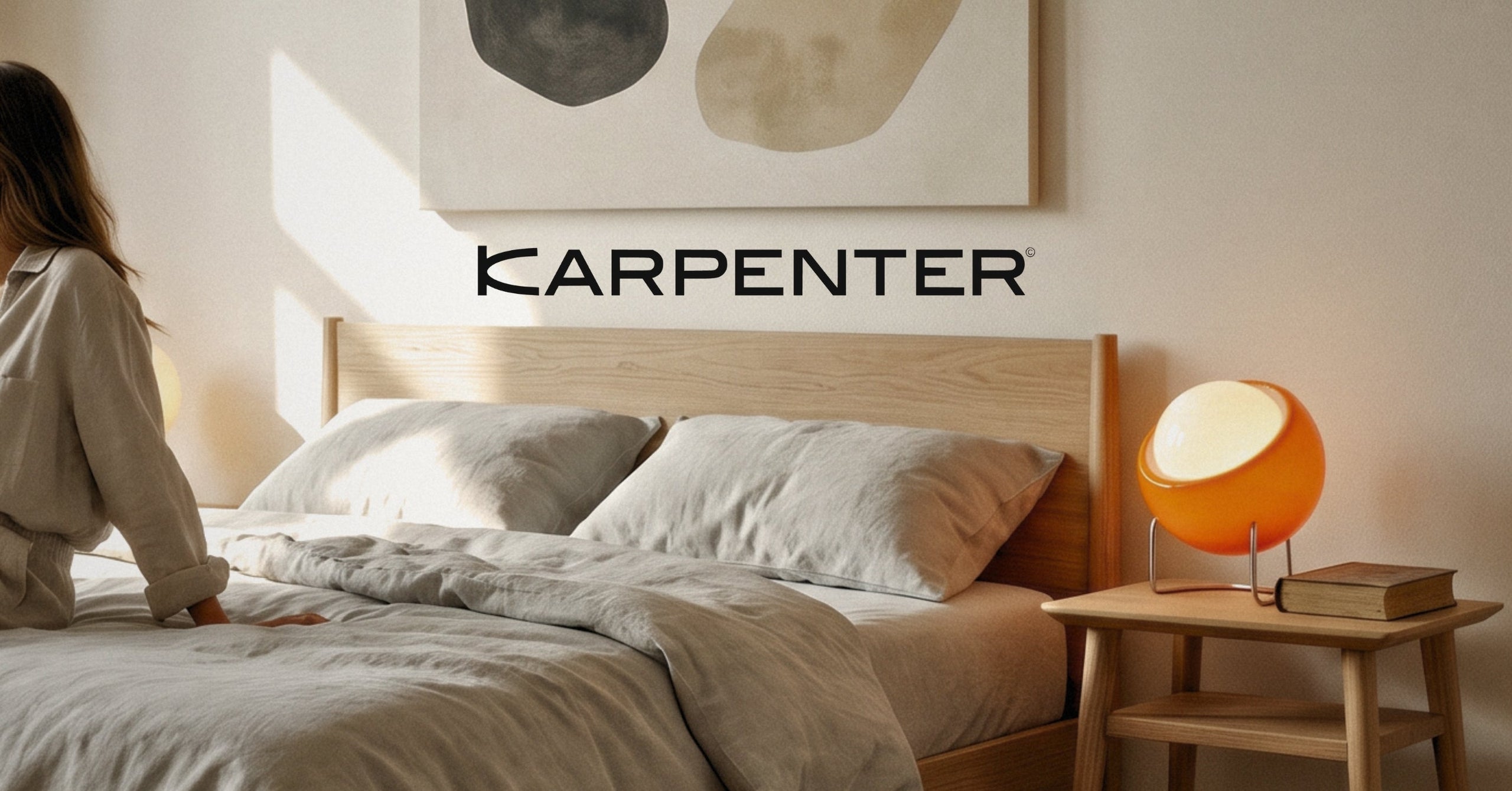 Karpenter solid oak bed with matching bedside table and warm ambient lighting in a minimalist bedroom setting