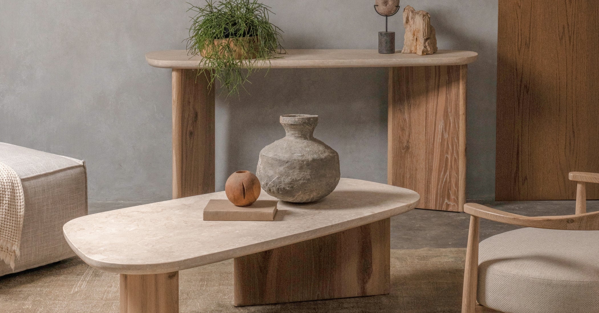 Travertine top coffee table with solid oak base styled with console table and modern timber furniture in a warm contemporary living room.