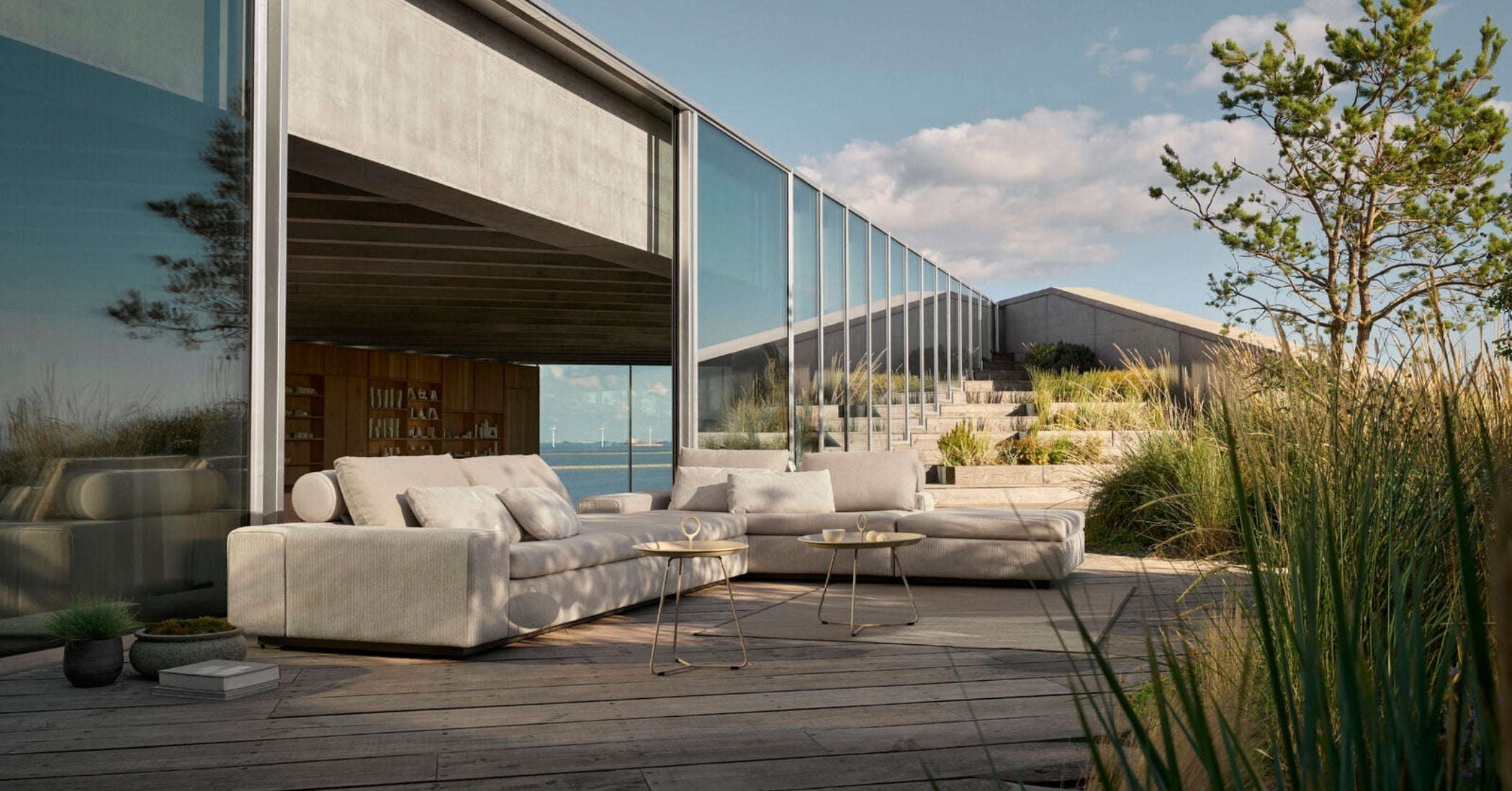 Architectural terrace with HOUE DRIFT modular outdoor lounge sofa and side tables, Danish outdoor furniture for modern patios and coastal living.