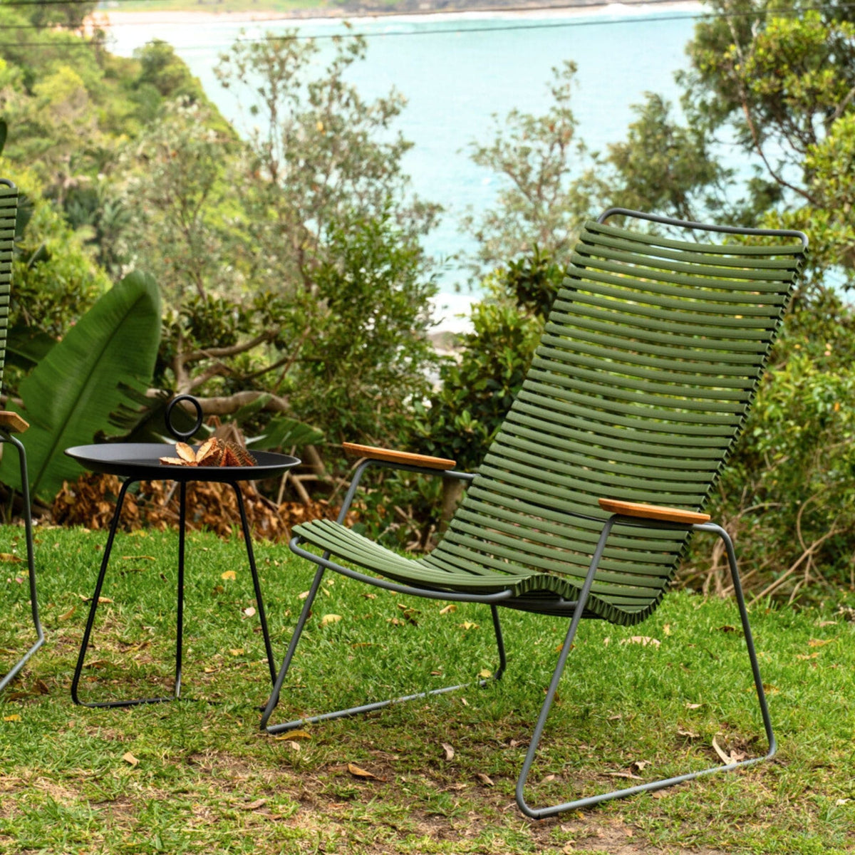 Green outdoor chair and table on grass.