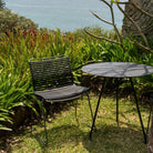 Black chair and table on a grassy lawn.