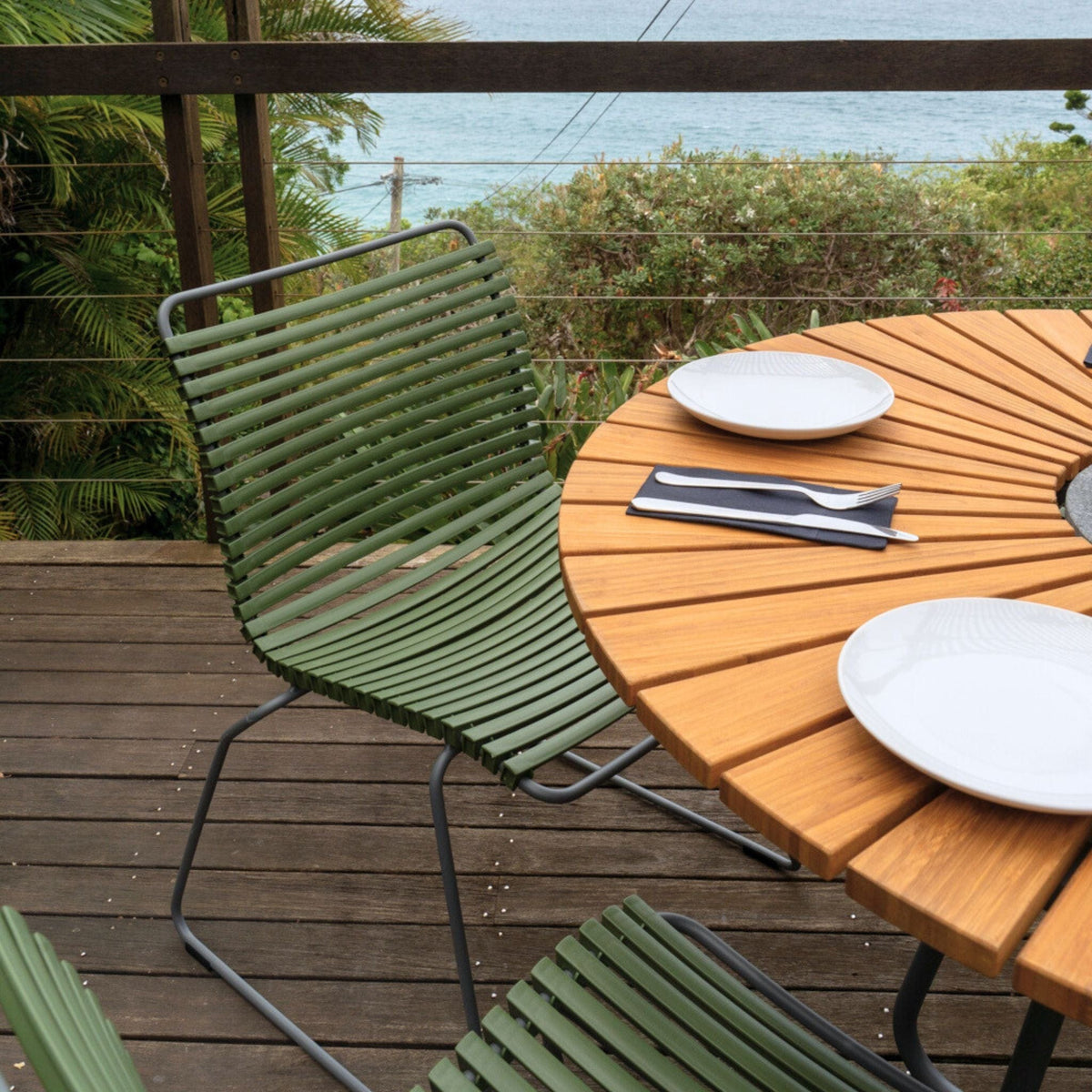 Green chair and wooden table set for two.