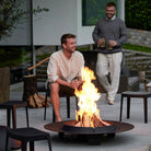 Outdoor fire pit with two men enjoying the flames