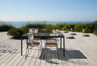 Outdoor dining table and chairs overlooking the ocean.