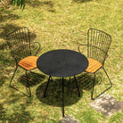 Black patio table and two chairs on grass.