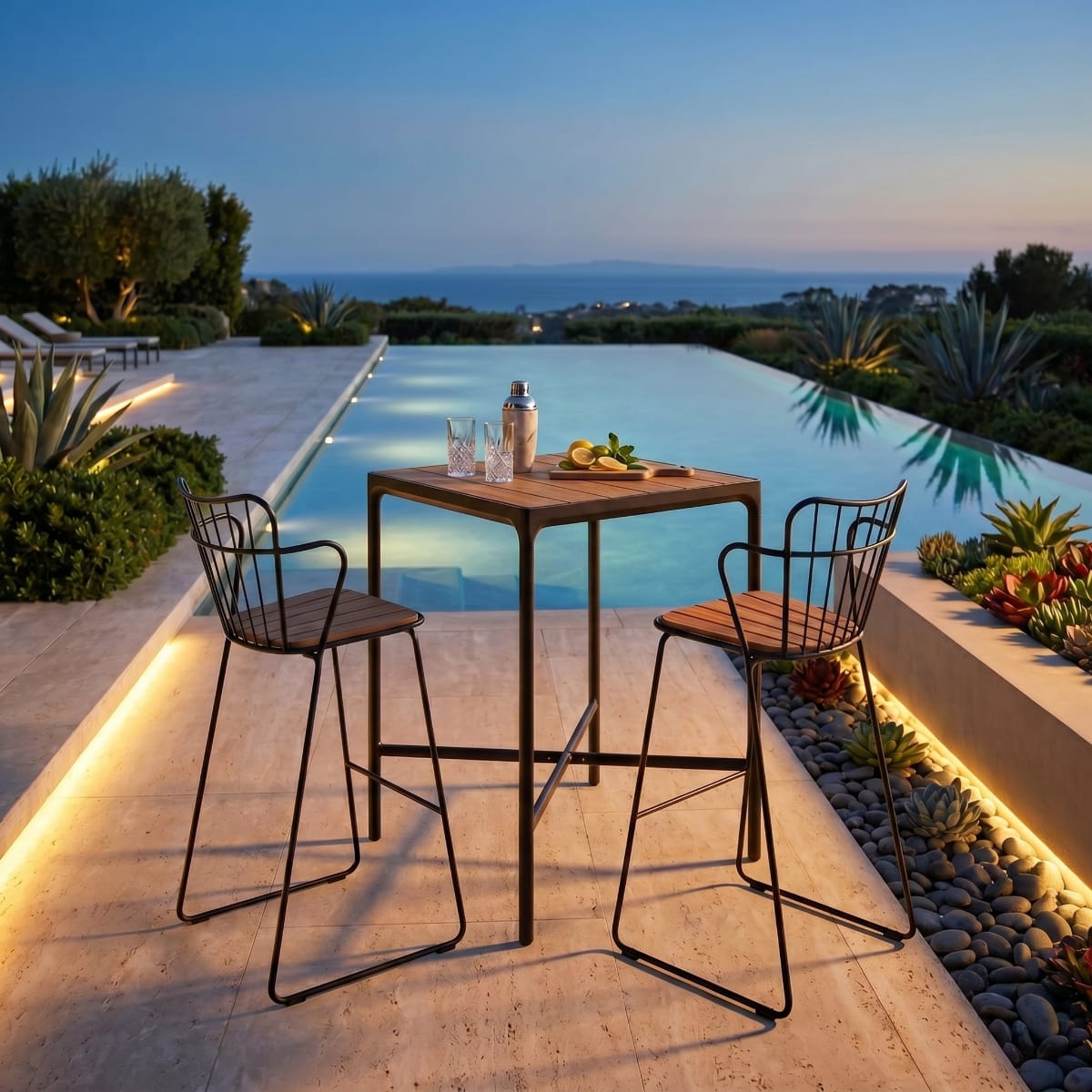 Outdoor dining setup by a pool with chairs and a table at dusk.