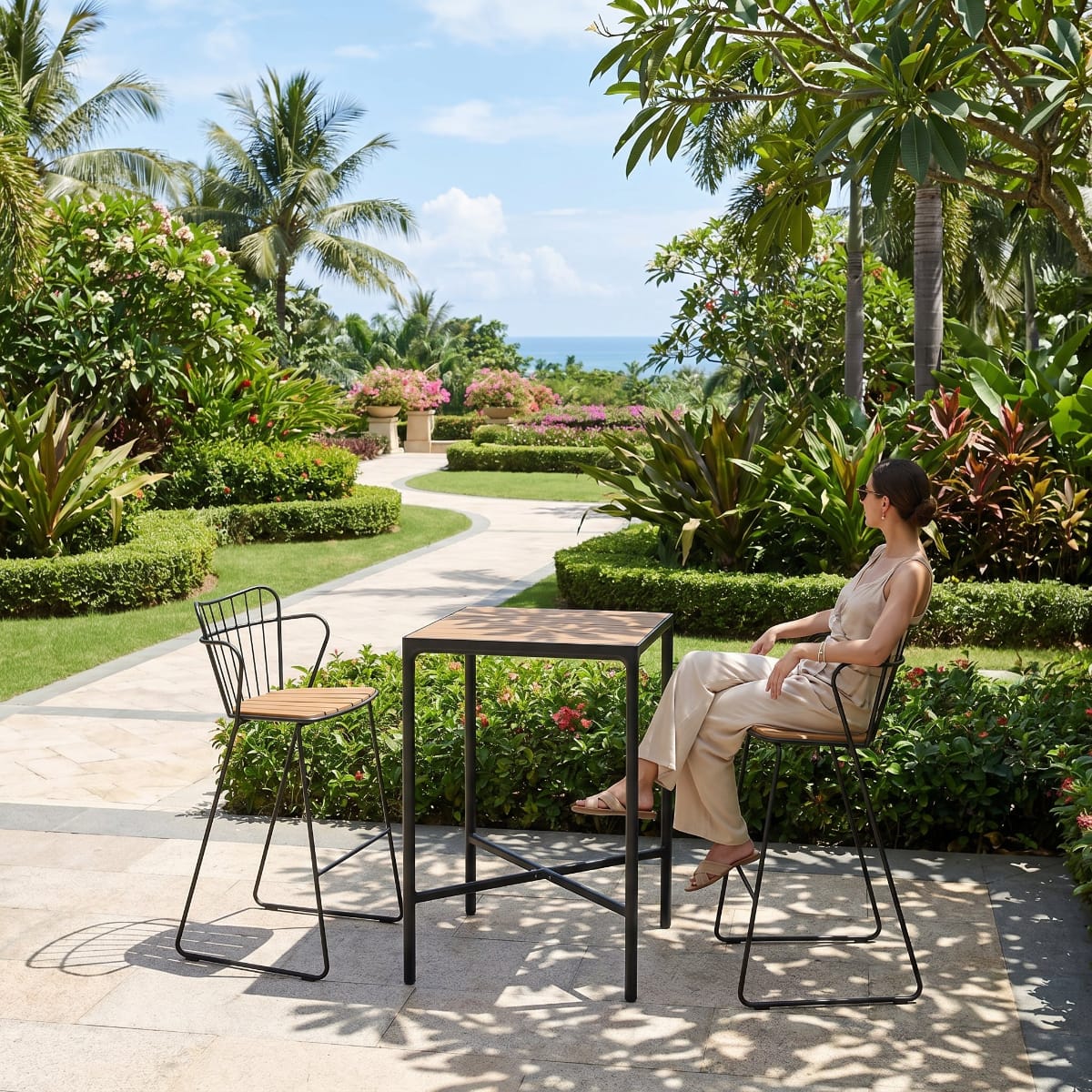 Woman sitting at a table in a tropical garden setting