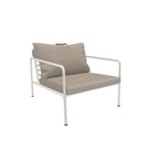 White framed outdoor armchair with tan cushion and pillow.