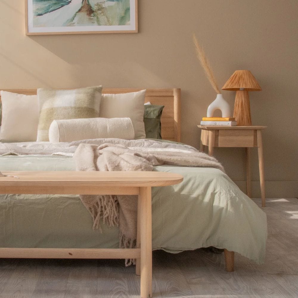 Bedroom with sage green bedding and wooden furniture