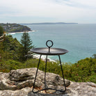 Black side table with handle overlooking the ocean.