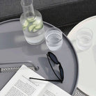 Modern table with water carafe, glasses, and sunglasses