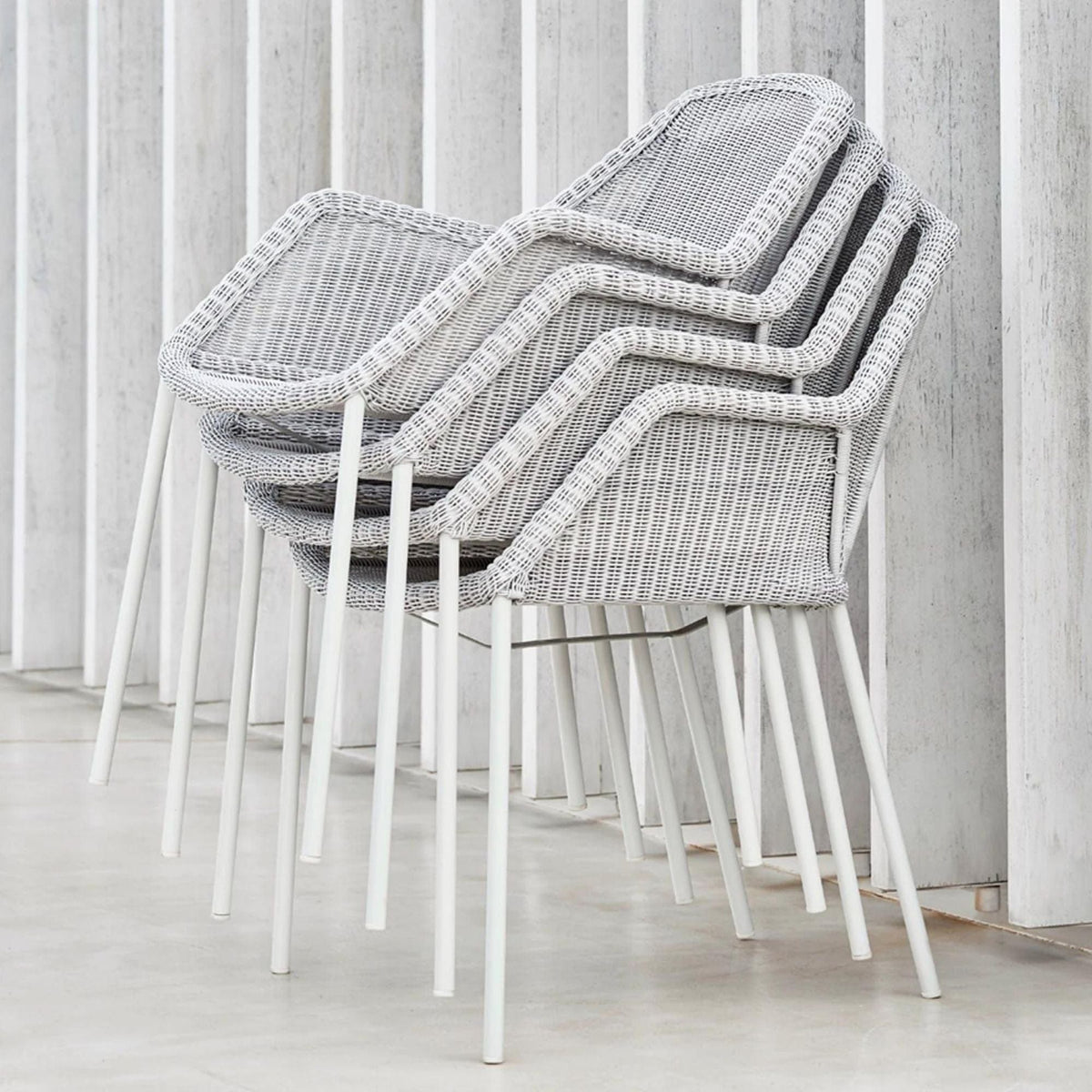 5464LW_3 Stacked gray wicker chairs with white legs