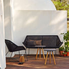 Black outdoor furniture set with sofa, chair, and side tables