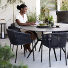 Woman at outdoor dining table with chairs