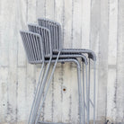 Stacked grey ROG chairs against concrete wall