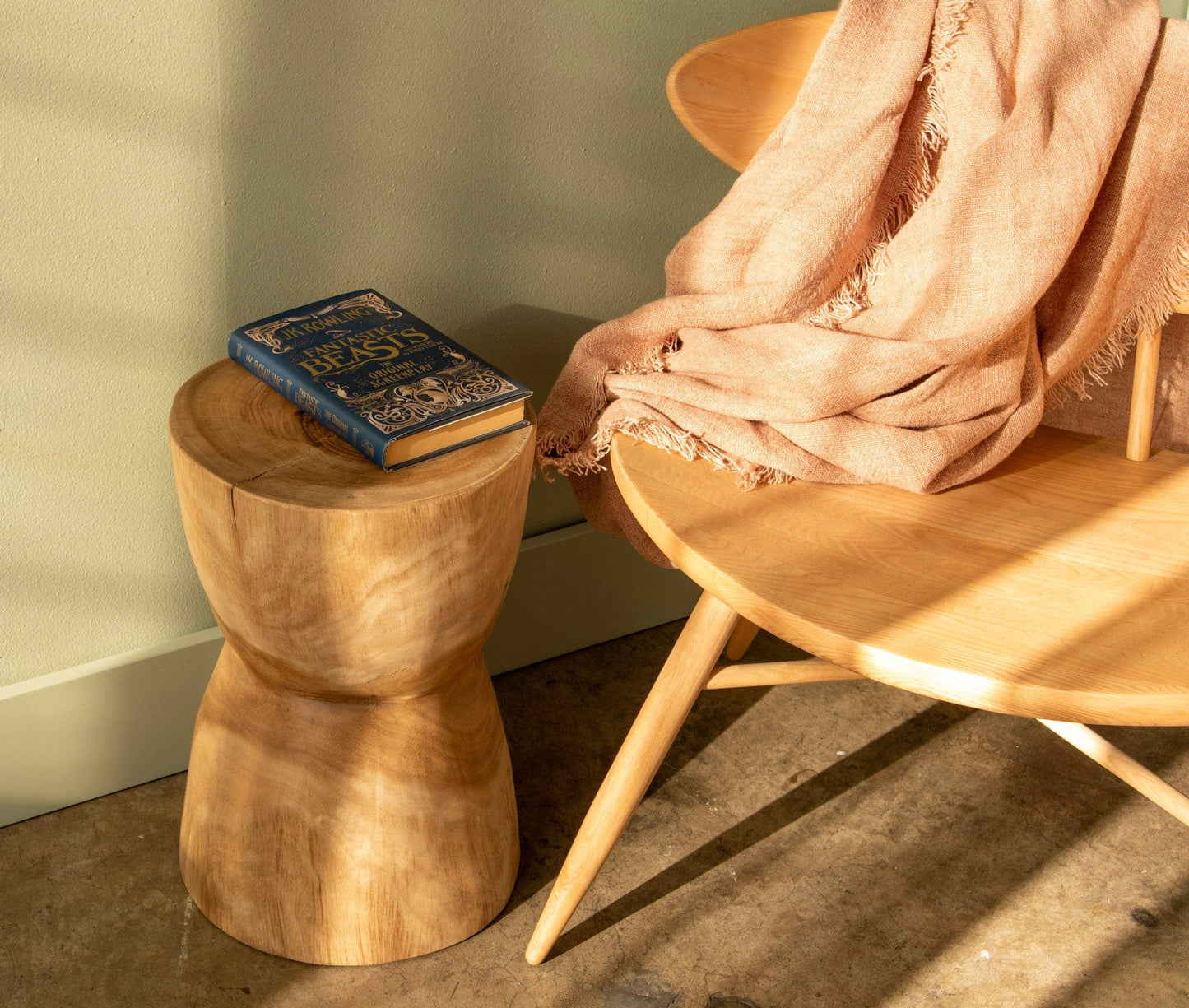 Wooden stool with book and chair with blanket
